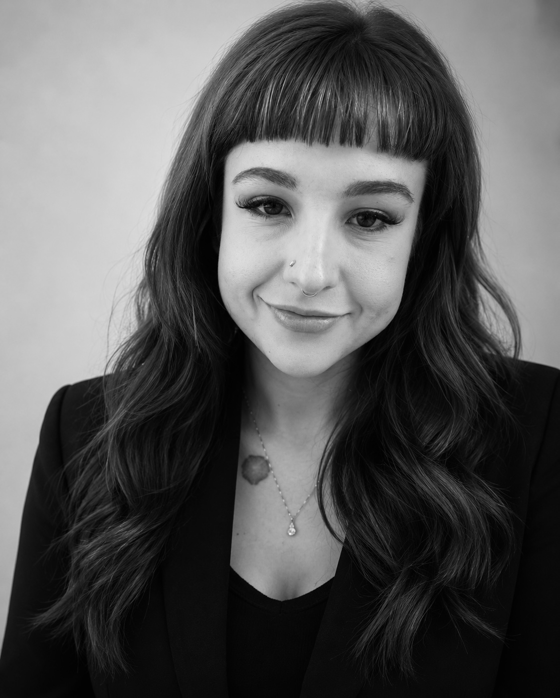 Author headshot of Airea Johnson in black & white, smiling young woman in long hair, bangs, a blazer