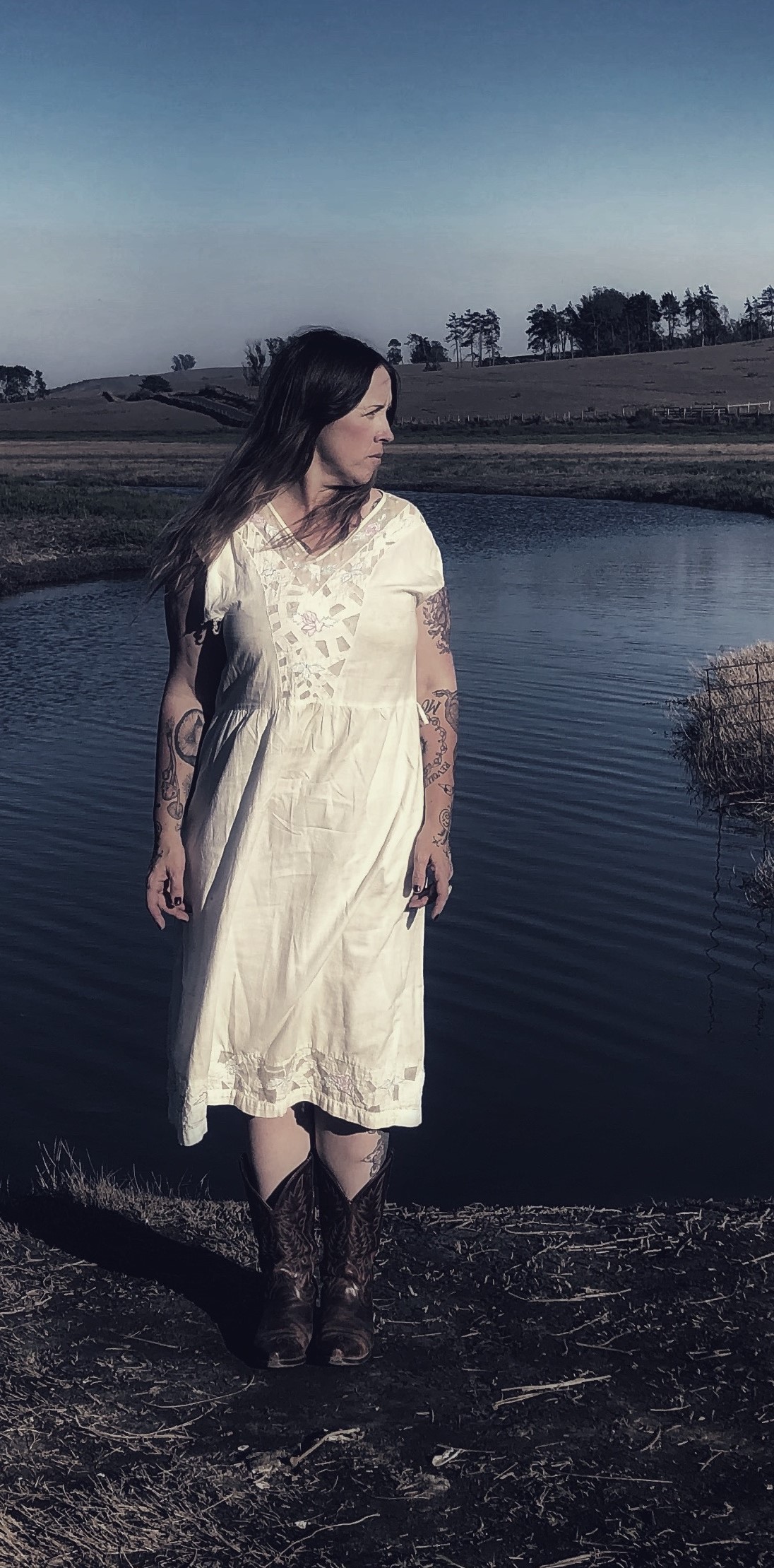 Woman in dress standing in front of pond