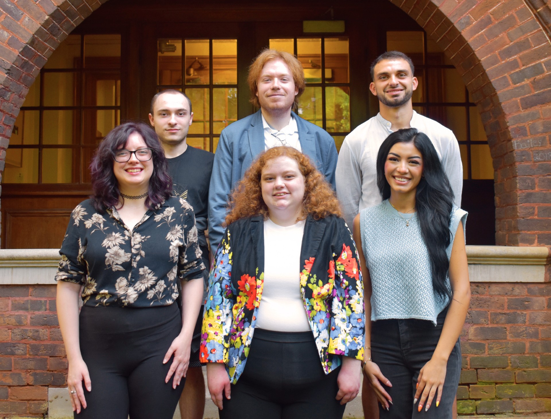 Six student editors standing together on Tusculum's campus smiling